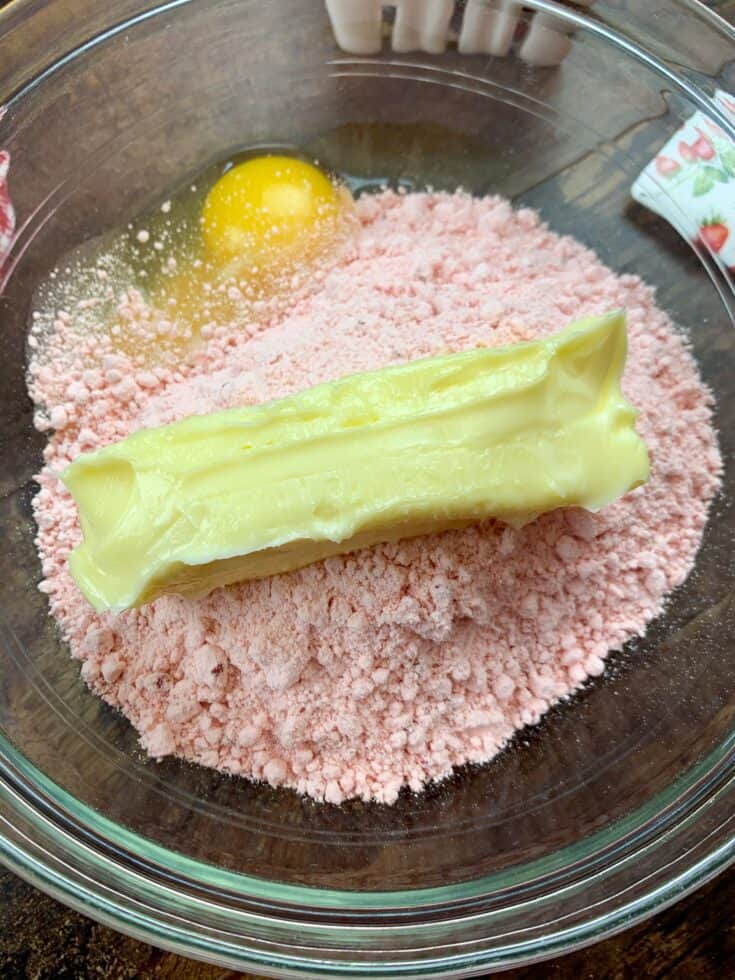 Butter, strawberry cake, and an egg in a glass bowl