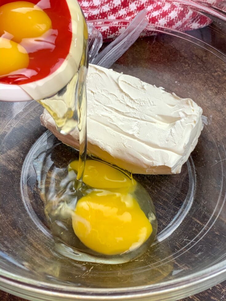 Eggs and cream cheese in a glass bowl.