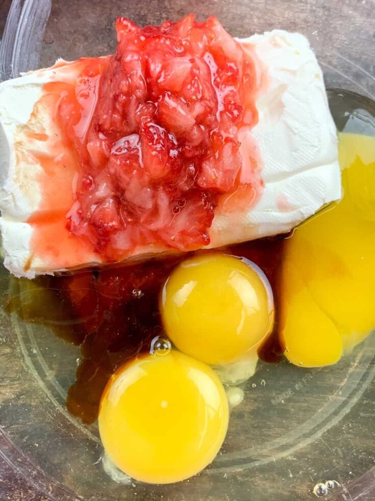 Strawberries, eggs, and cream cheese in a large bowl