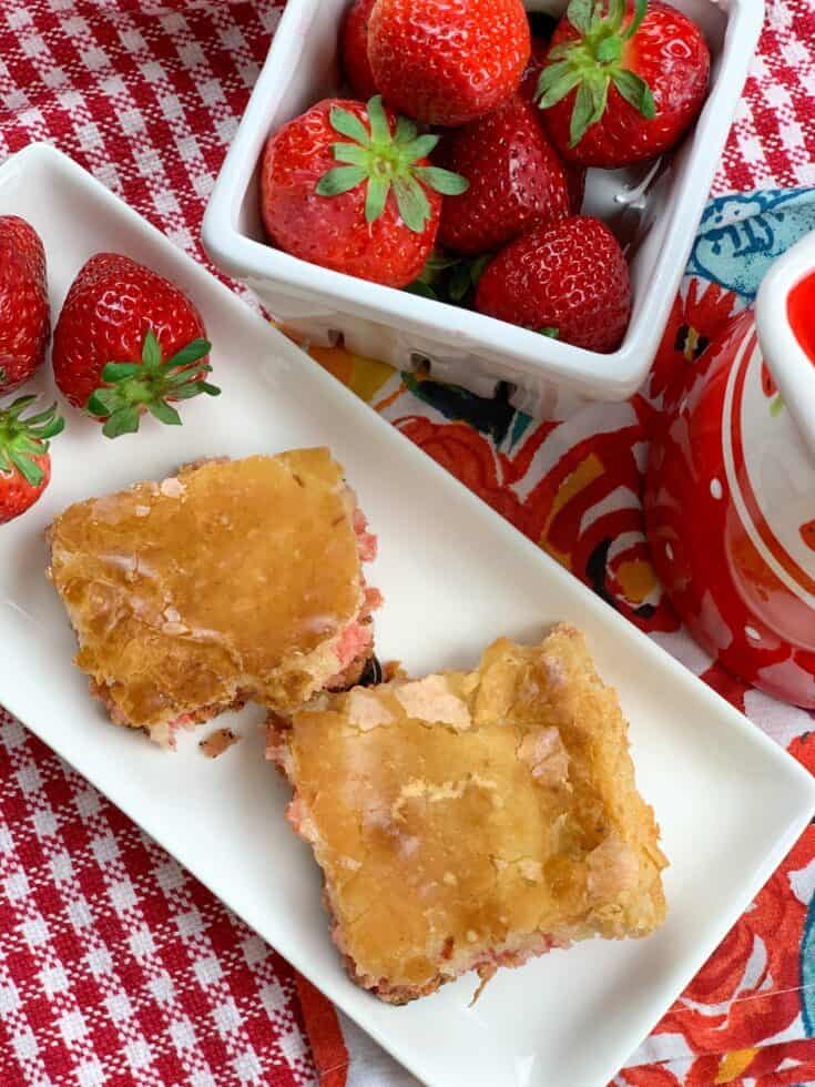 Strawberry chess squares on a plate with strawberries on the side