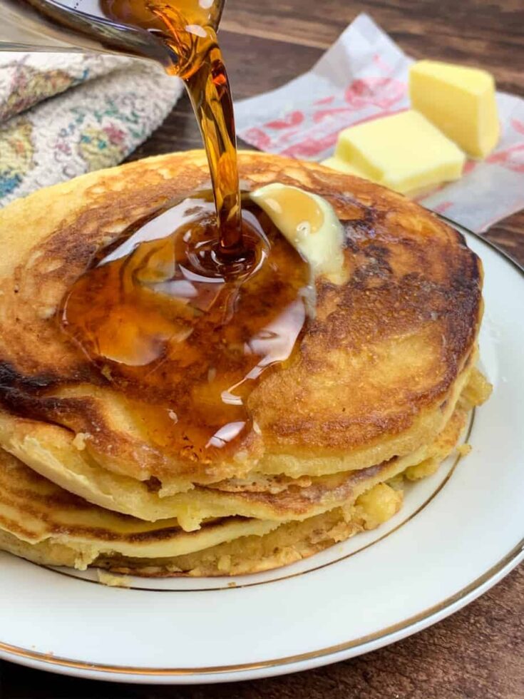 Pouring syrup over Jiffy Cornbread Pancakes