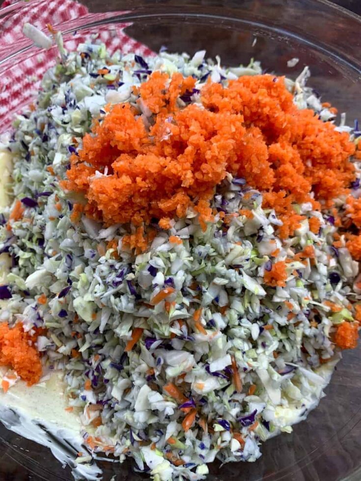 Grated carrots with cabbage for coleslaw in a glass bowl