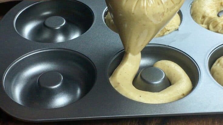 Pouring donut batter into a donut baking pan