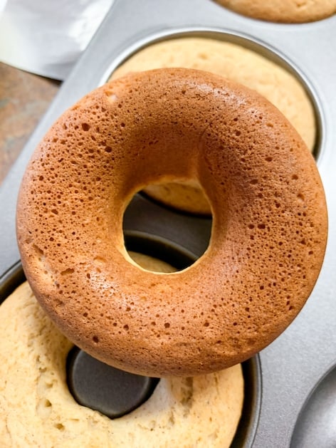 A baked donut sitting on top of the baking pan