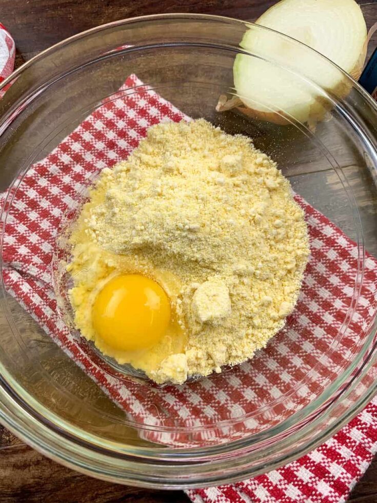 Jiffy Corn Muffin Mix and an egg in a glass bowl. 