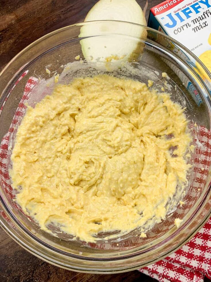 Hush puppy batter mixed up in a glass bowl. 