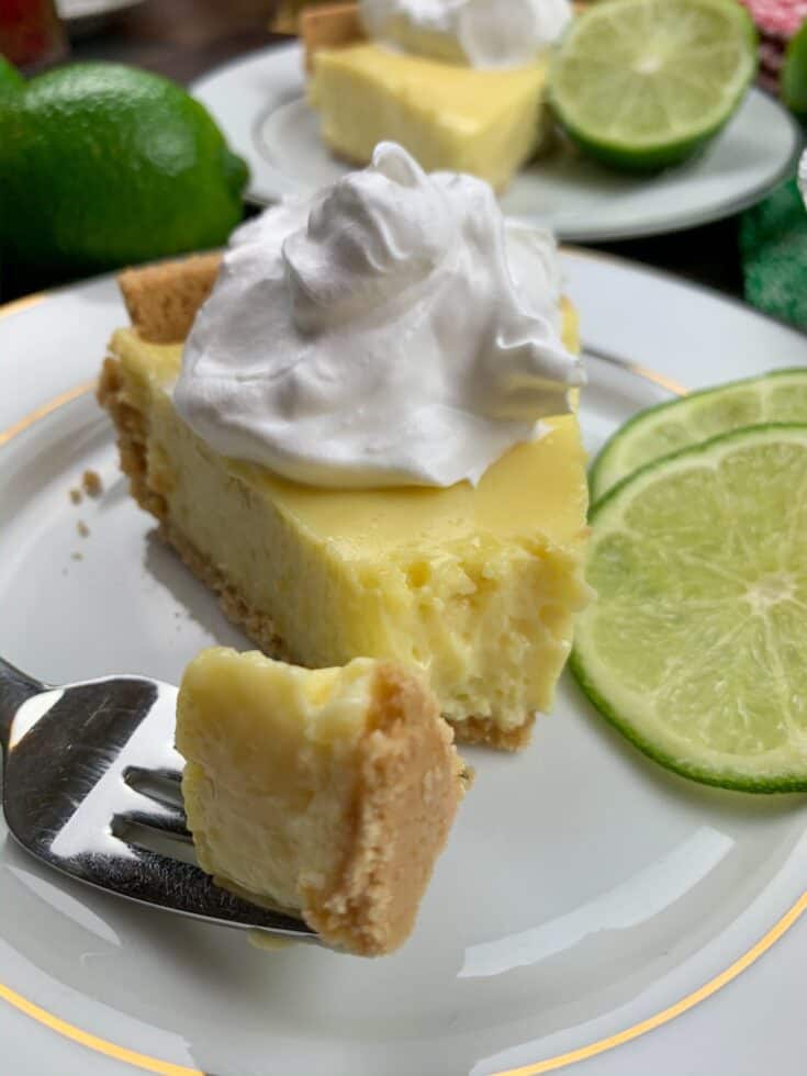 Key lime pie on a plate with slices of lime